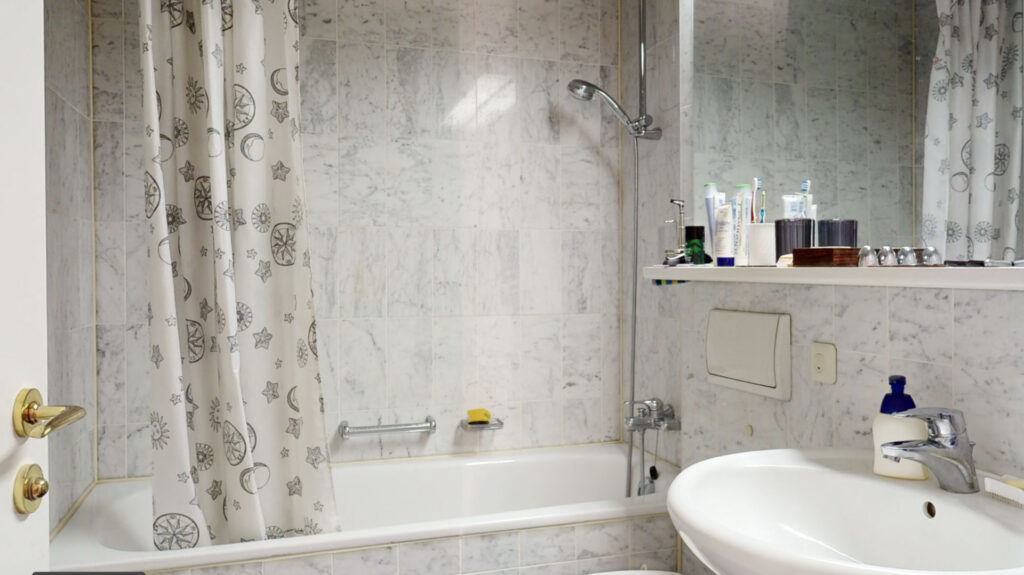 Bathroom with patterned tiles, bathtub and original shower curtain, Haidhausen