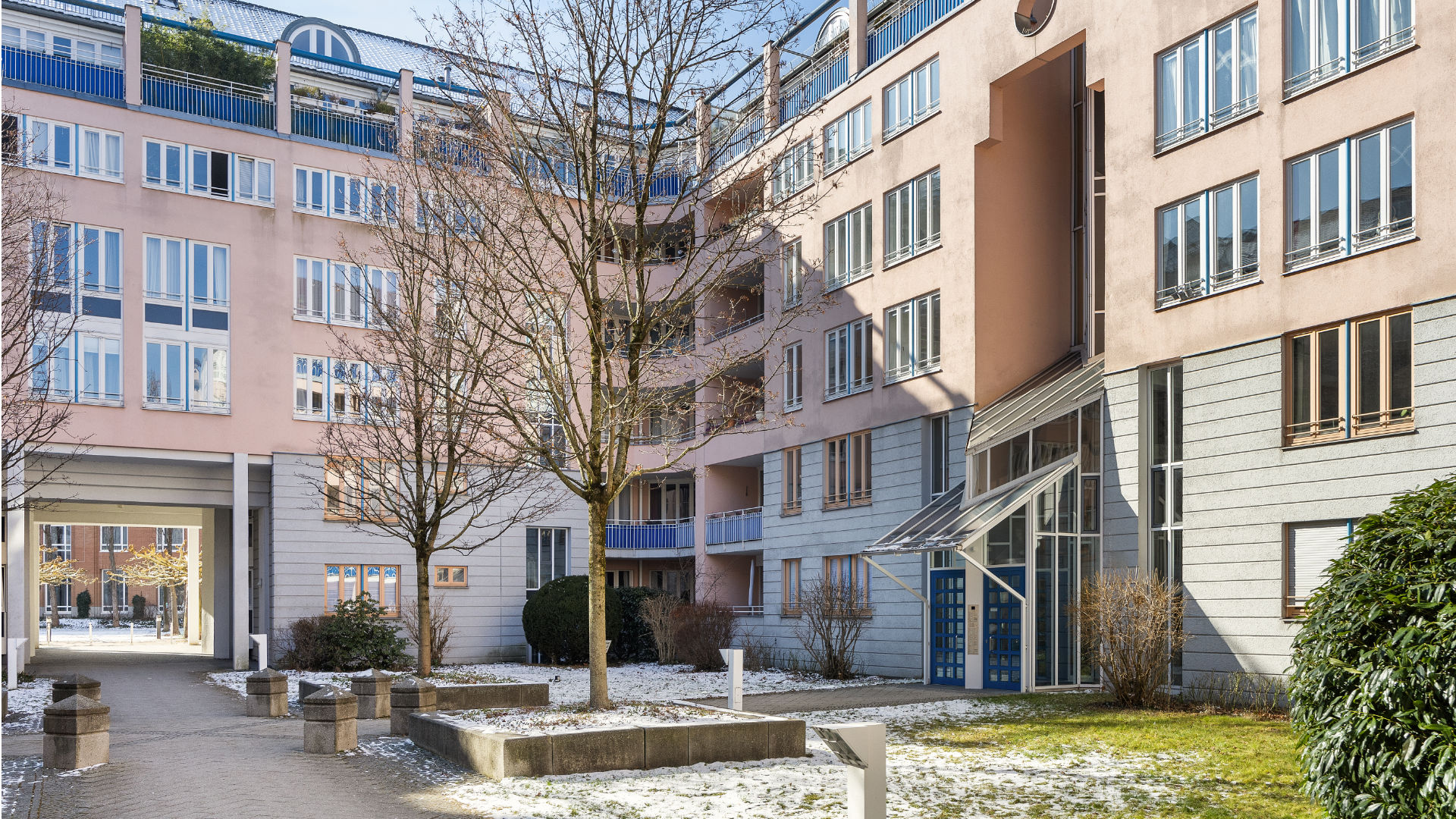 Courtyard of a residential complex with terraces, balconies, and a landscaped green area in Munich-Haidhausen