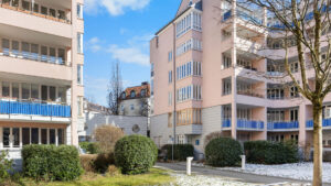 Multi-story residential complex with a pink and cream-colored facade and a landscaped inner courtyard in Munich-Haidhausen