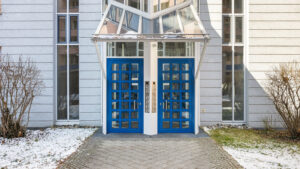 Representative entrance with blue double doors and glazed canopy of a residential building in Munich-Haidhausen