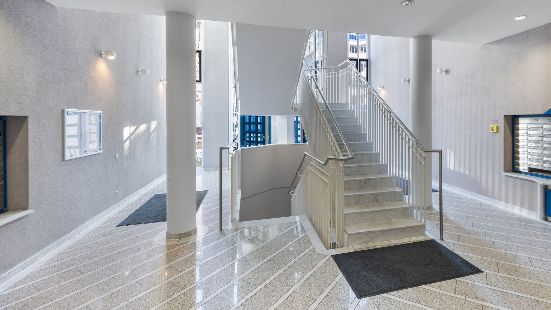 Representative staircase with shiny marble floor, stone stairs, and mailboxes in an apartment building in Munich Haidhausen