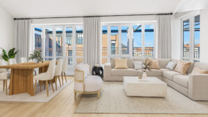 Modern bright living room with dining area, beige sofa, and floor-to-ceiling windows with city views in Haidhausen