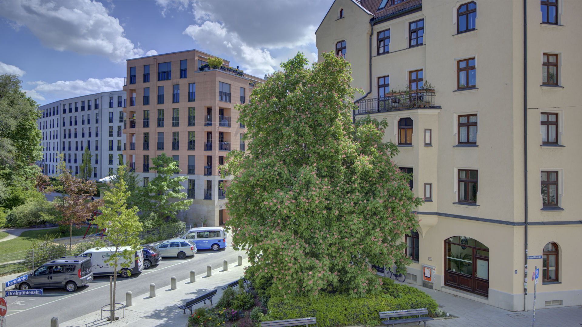 View from the window of bright old and new building facades with trees in Munich-Isarvorstadt