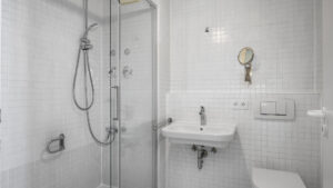 Tiled bathroom with shower cabin, sink, and toilet in Munich Isarvorstadt rental apartment