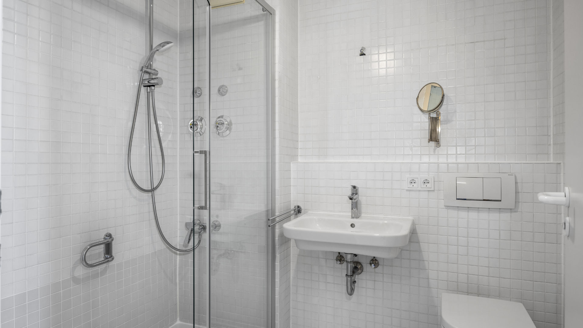Tiled bathroom with shower cabin, sink, and toilet in Munich Isarvorstadt rental apartment