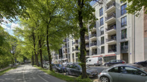 Summer tree-lined avenue with parked cars in front of a residential building in the Isarvorstadt area