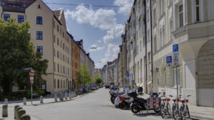 Street intersection with colorful old building facades and rental bicycles in Munich's Isarvorstadt district in sunny weather