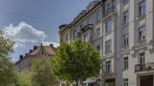 Multi-story historical old building facades with bay windows under a blue sky in Munich-Isarvorstadt
