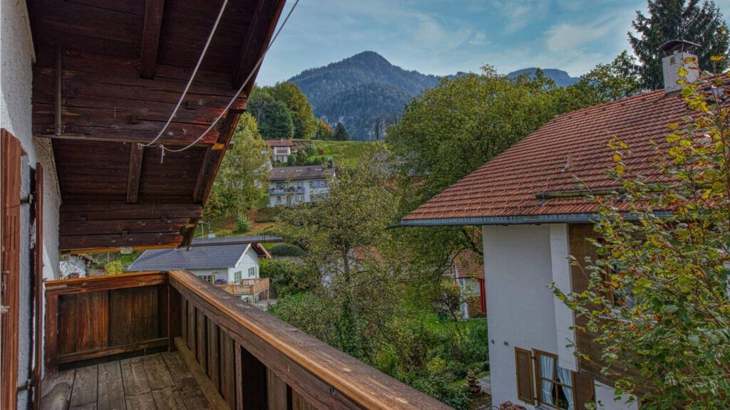 Hölzerner Balkon mit Blick auf Berge und Nachbarhäuser des Hauses in Kochel am See