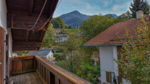 Hölzerner Balkon mit Blick auf Berge und Nachbarhäuser des Hauses in Kochel am See