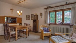 Esszimmer mit Holztisch, Korbstühlen und Kruzifix an der Wand im Haus in Kochel am See