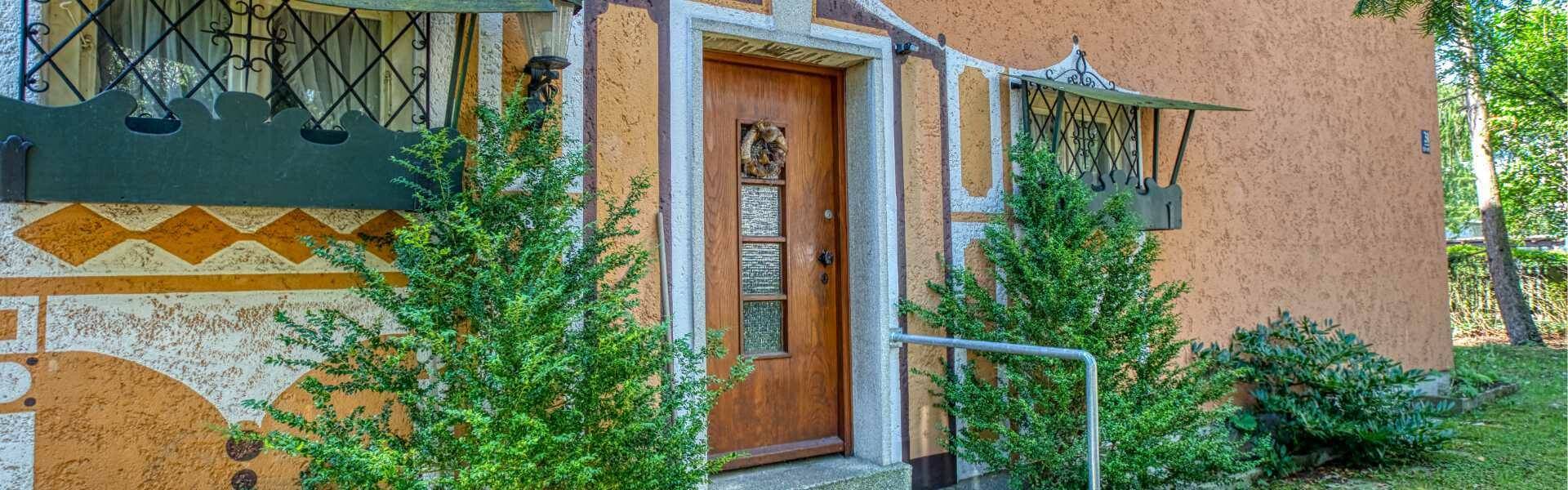 Detailed view of the decorated entrance with wooden door and bay windows on the property in Munich-Laim