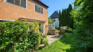 Rear view of the house with terrace and well-kept garden on the property in Munich-Laim