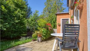 Sunny terrace with seating and blooming plants on the property in Munich-Laim