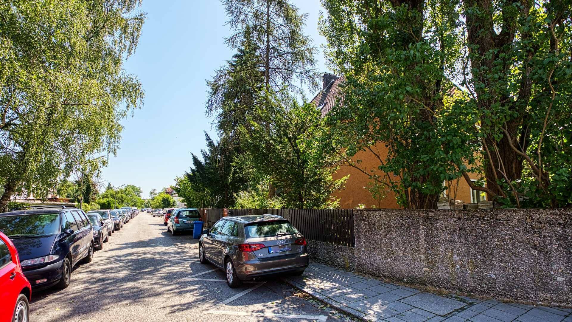 Tree-lined residential street with parked cars in the vicinity of the property in Munich-Laim
