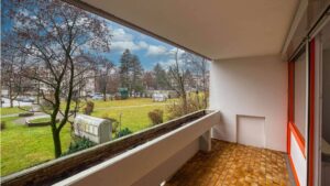 Balkon mit Parkettboden und Blick auf blühende Bäume einer Wohnung in München-Laim