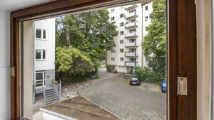 View from the window of a green inner courtyard with a residential building in Munich-Lehel