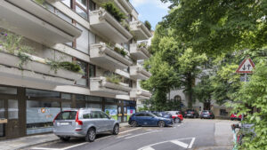 Multi-story residential building with wraparound balconies and greenery in Munich-Lehel