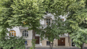 Historic villa with dense ivy growth and trees on the facade in Munich-Lehel