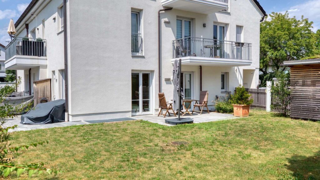 Exterior view of the apartment building with the garden apartment in Munich-Lerchenau, featuring balconies and a well-maintained garden