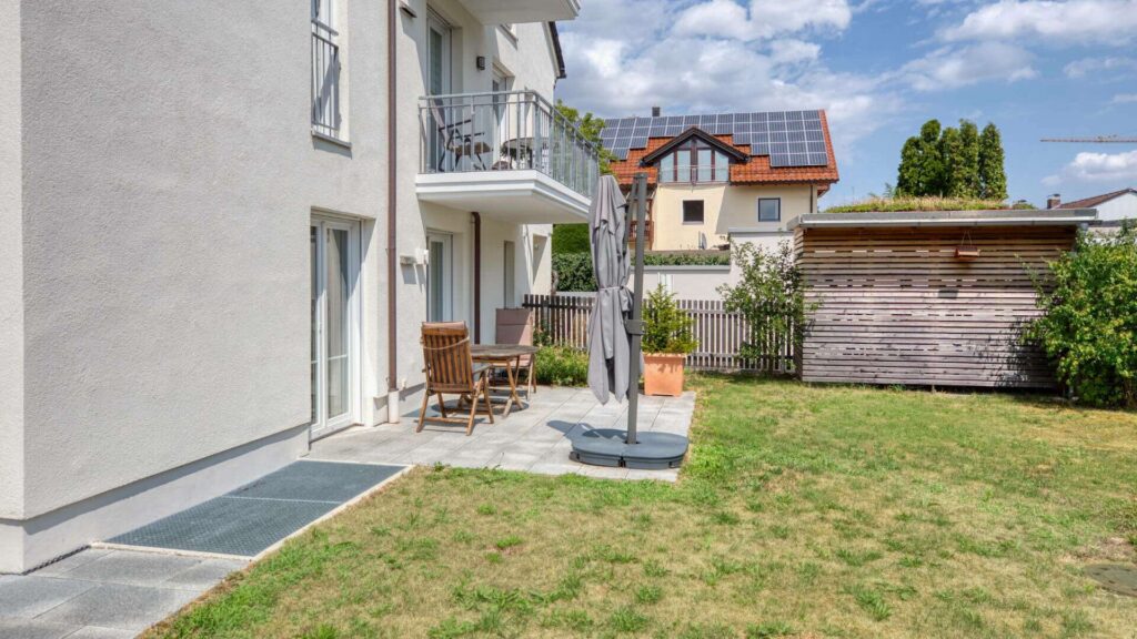 Terrace of the ground-floor apartment in Munich-Lerchenau with a view of the lawn and wooden garden shed