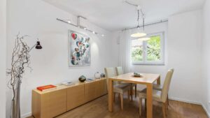 Dining room in Lerchenau with a wooden table, chairs, sideboard, and art on the wall.