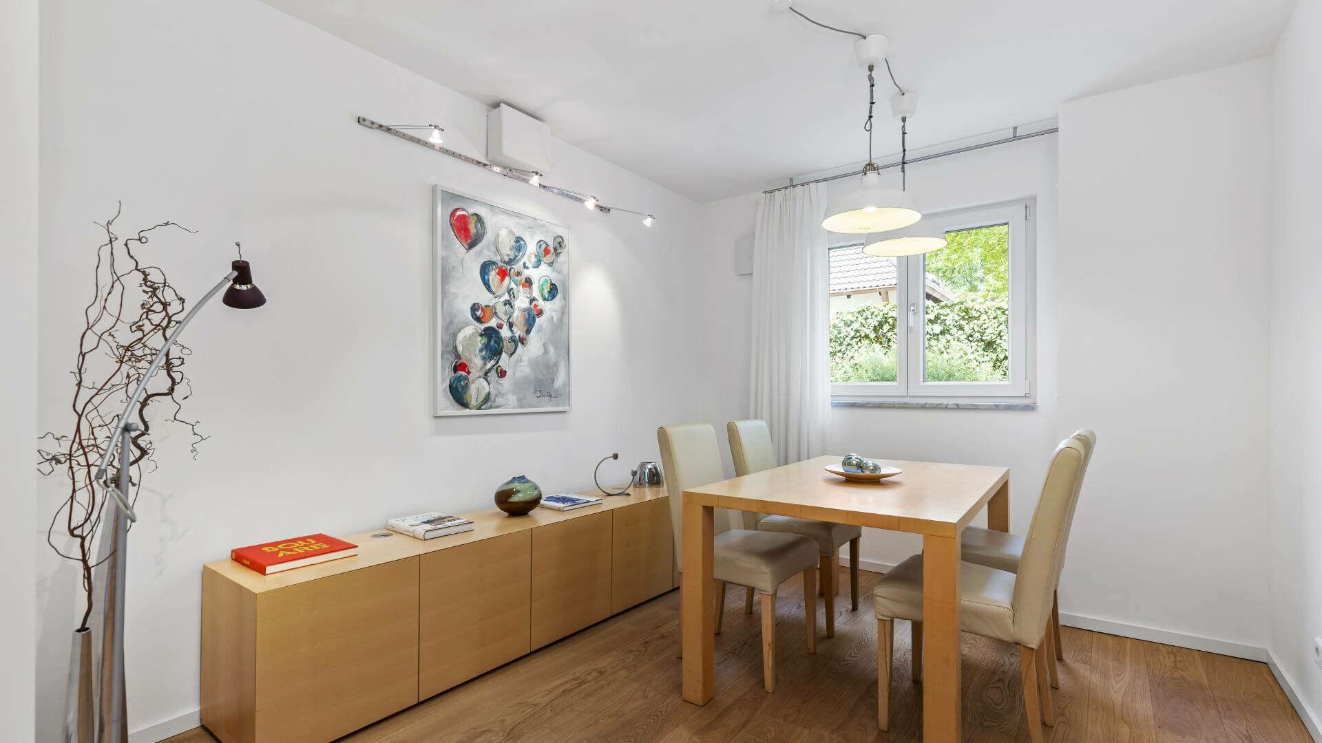 Dining room in Lerchenau with a wooden table, chairs, sideboard, and art on the wall.