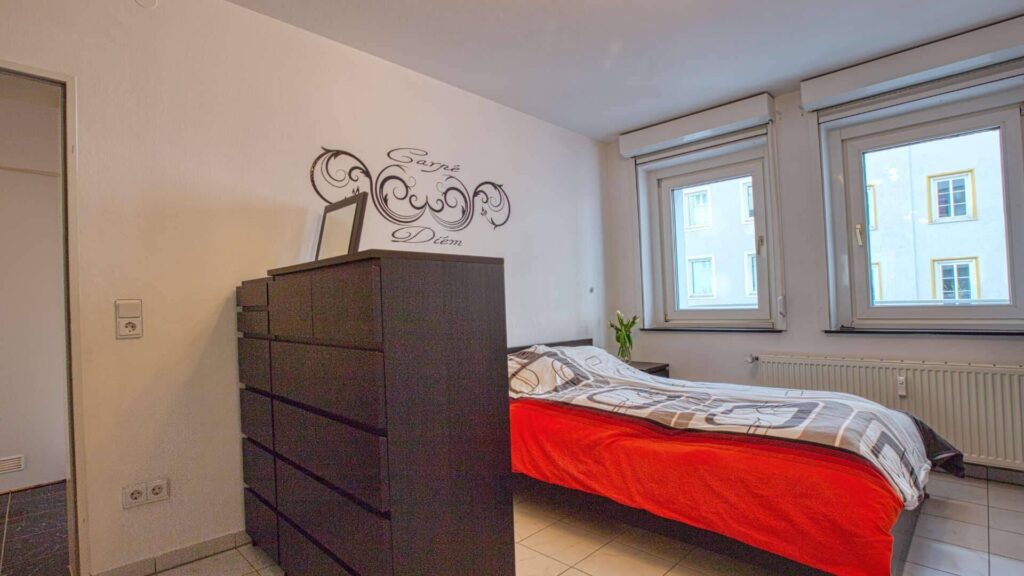 Möbliertes Schlafzimmer mit Doppelbett und Kommode in der Wohnung in München-Maxvorstadt