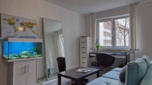 Möbliertes Zimmer mit Aquarium, Sofa und Schreibtisch in der Wohnung in München-Maxvorstadt