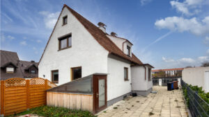 Gepflasterte Terrasse mit Holzzaun am Giebelhaus im Stadtteil Milbertshofen in München