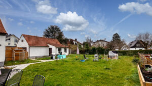 Rückseite des Hauses mit großer Rasenfläche und Nebengebäude im Stadtteil Milbertshofen in München