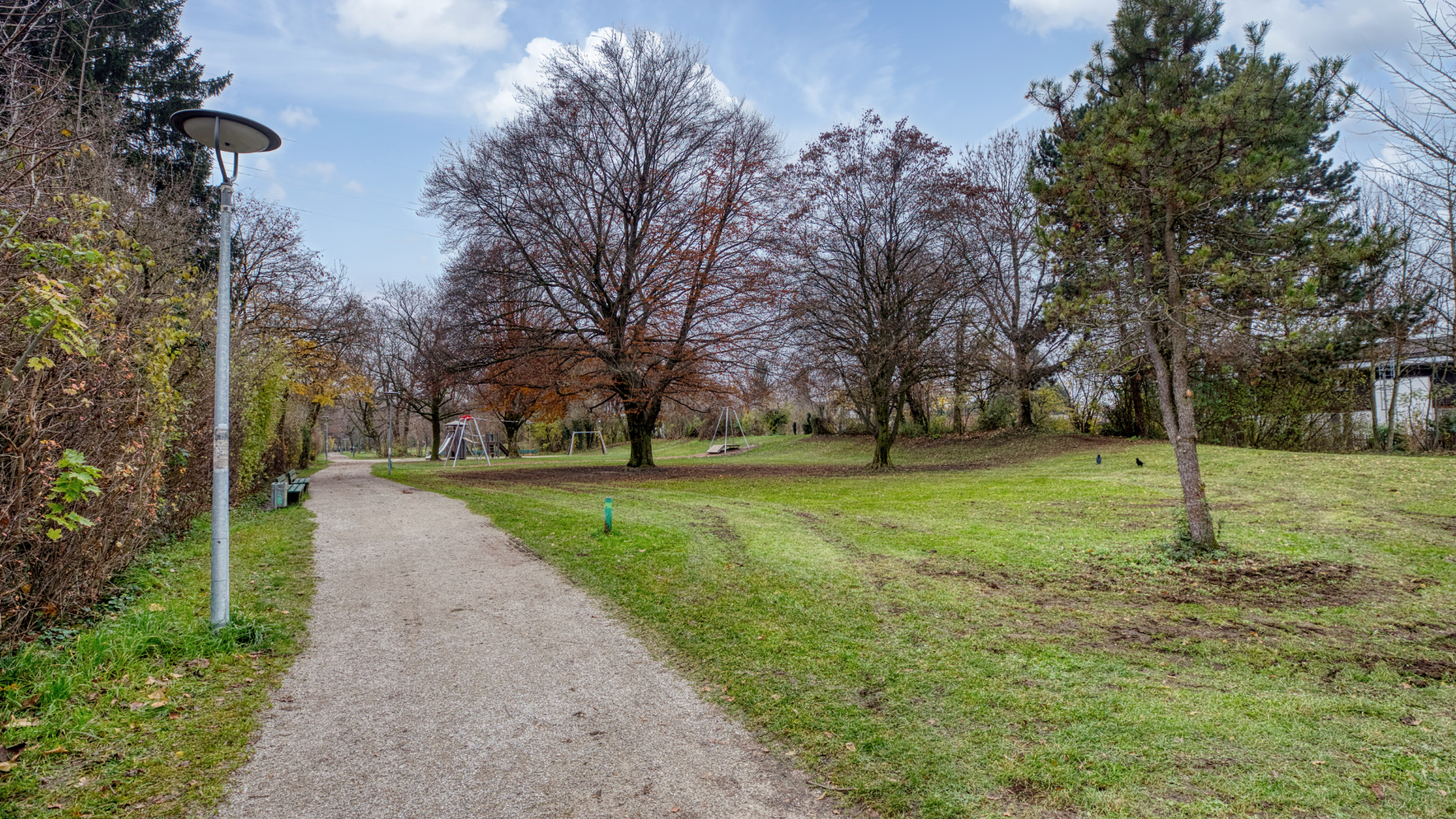Kiesweg zwischen Wiesen und Bäumen führt über ein Grundstück in München-Milbertshofen.