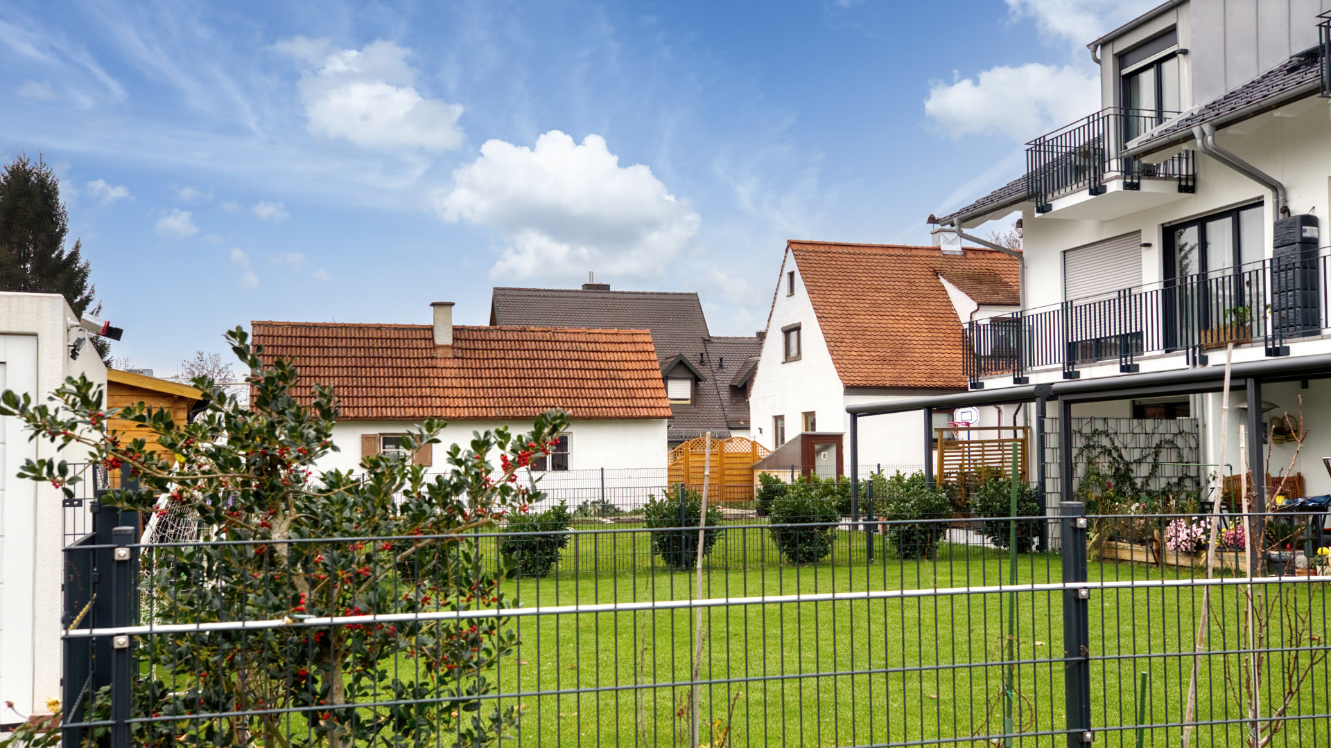 Gepflegter Garten mit Rasenfläche und Zaun bei einem Grundstück im Stadtteil Milbertshofen in München