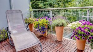 Balcony with sun lounger and colorful flower pots in an apartment in Munich-Milbertshofen