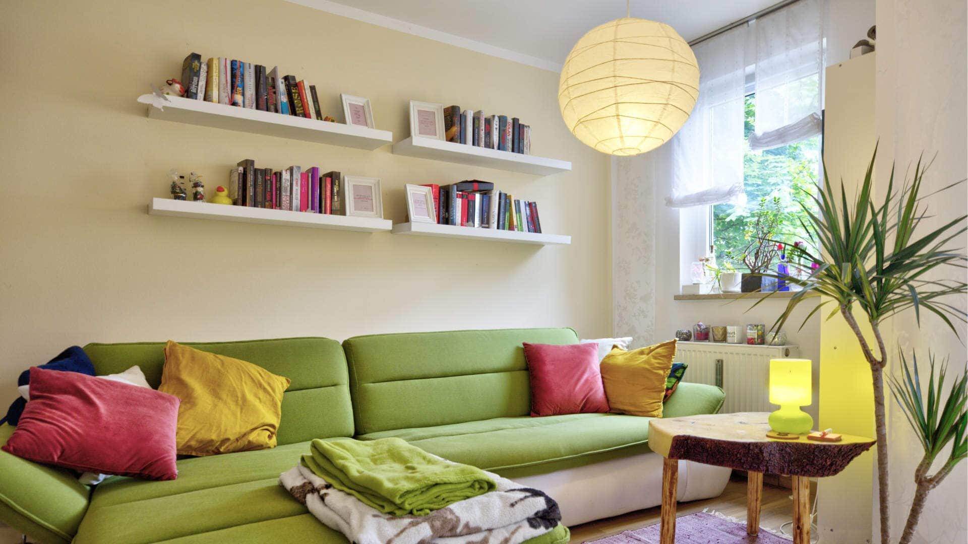 Wohnzimmer mit grünem Sofa und Bücherregalen in einer Wohnung in München-Moosach