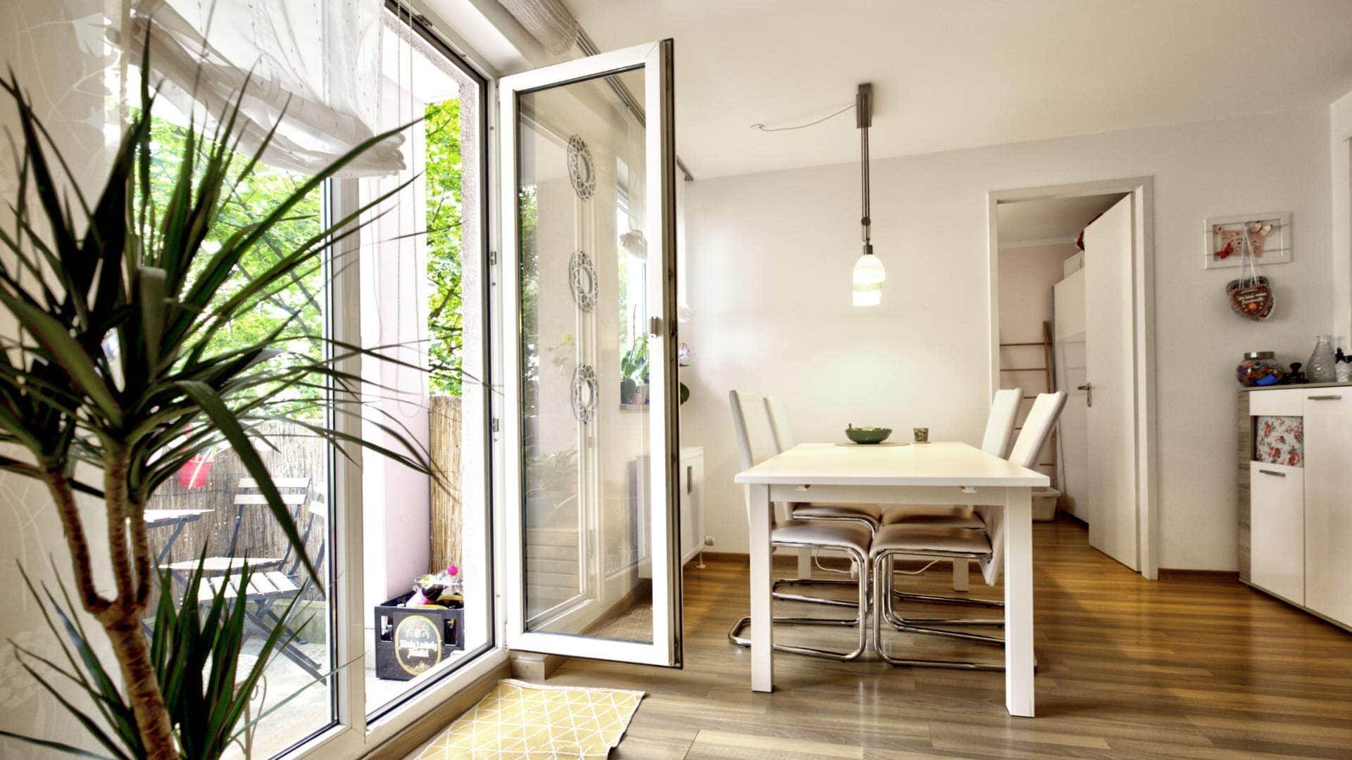 Essbereich mit geöffneter Balkontür und Blick zur Küche in einer Wohnung in München-Moosach