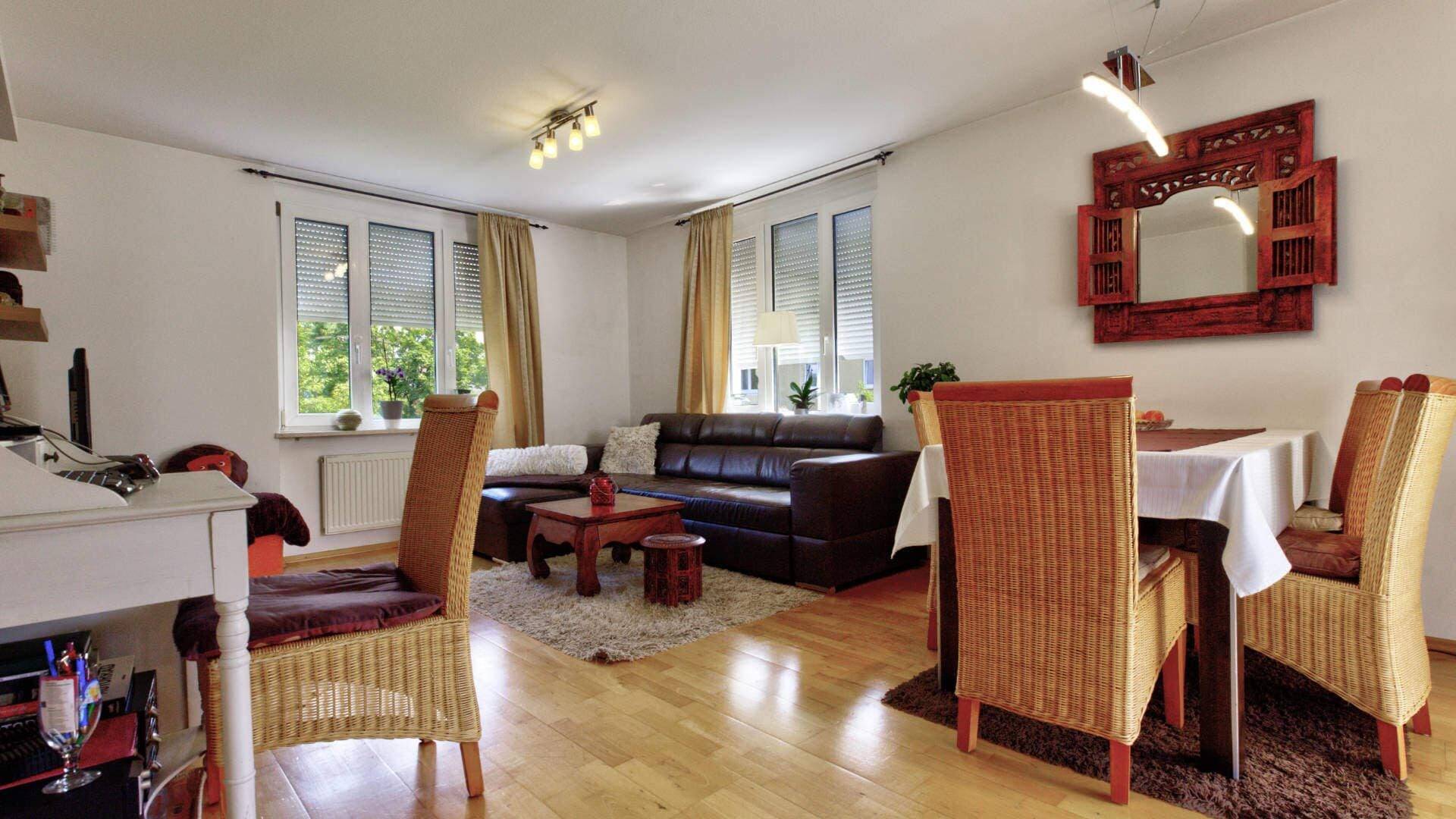 Wohn-Esszimmer mit Ledersofa und Rattanstühlen in einer Wohnung in München-Moosach