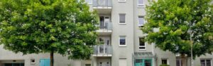 Fassade des Wohnhauses mit Balkonen und Bäumen in München-Moosach, Rogers Immobilien