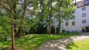 Well-maintained green space with old trees in front of the residential complex in Munich-Moosach