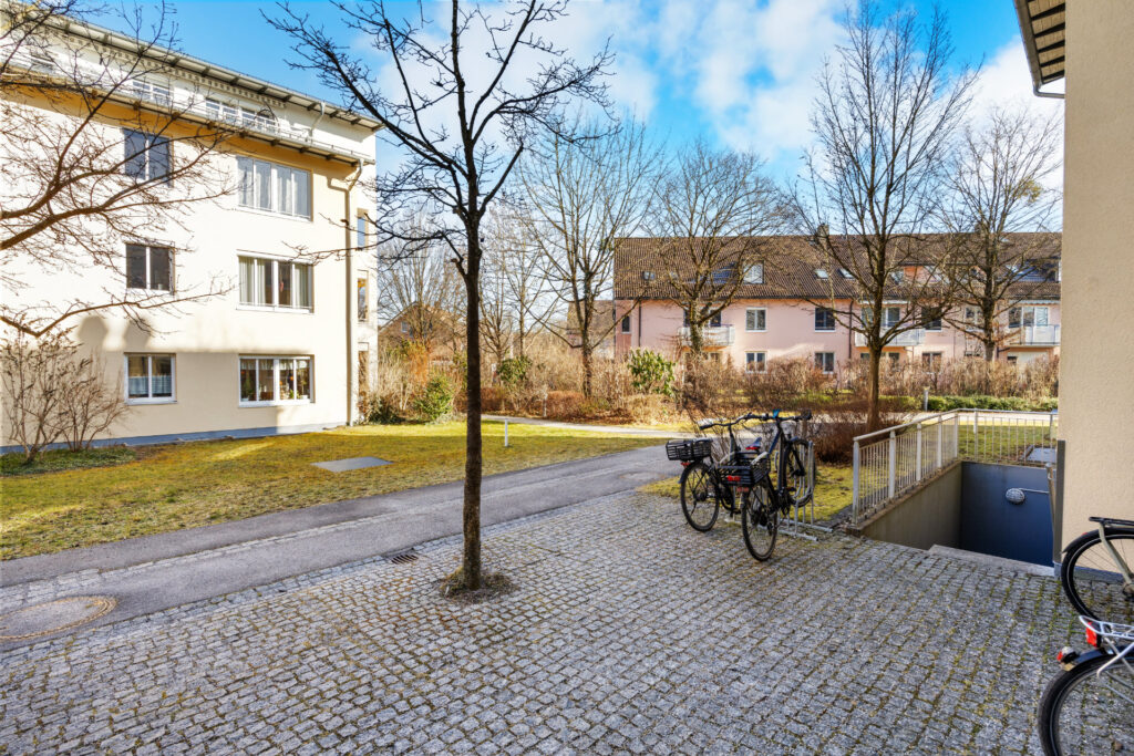 Cobblestone courtyard of the Großhadern residential complex with bicycles and cellar entrance