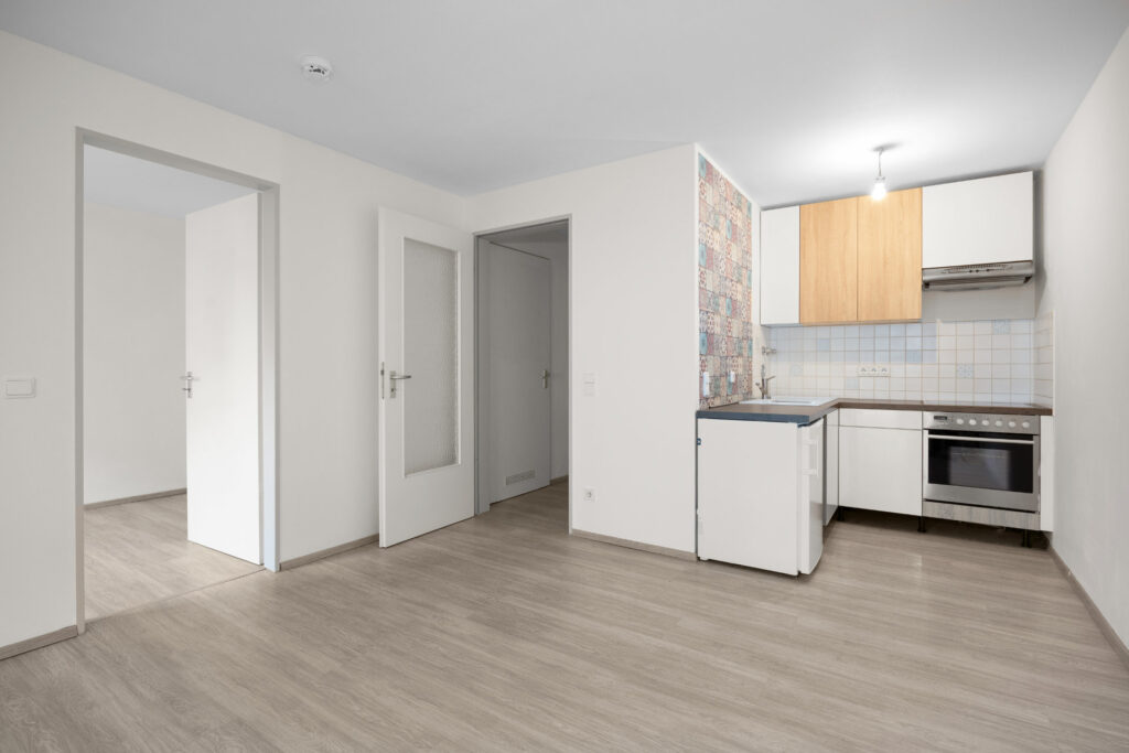 Open kitchen of the apartment in Großhadern in its existing condition with patterned tiles and light flooring