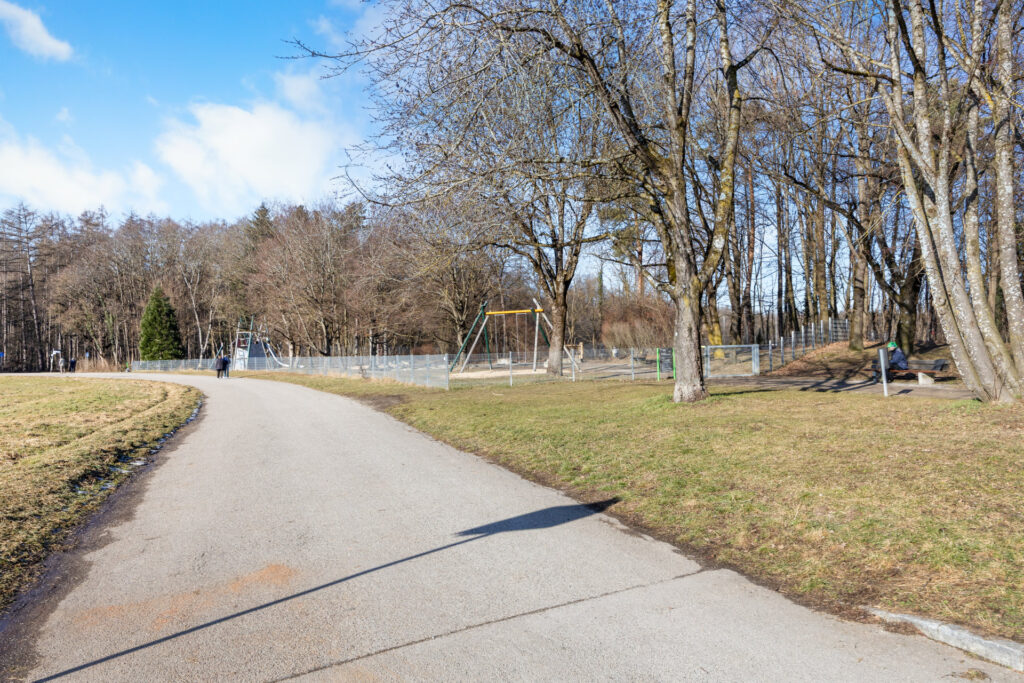 Park path with a fenced playground in the vicinity of the apartment in Großhadern