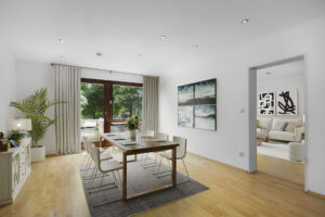 Virtuelle Einrichtung zeigt Essbereich mit Holztisch und Durchblick zum Wohnzimmer in München-Lehel