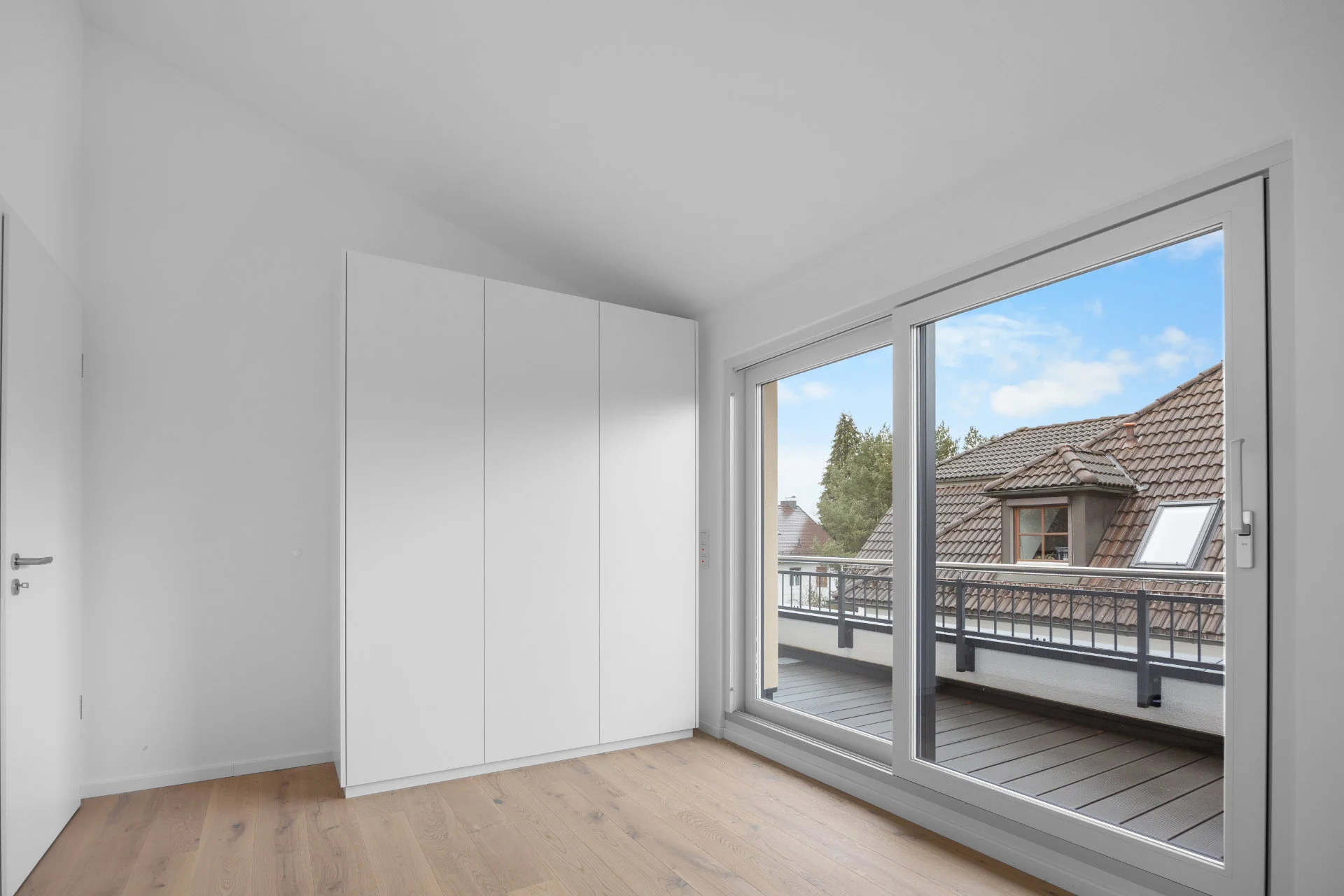 Empty bedroom with built-in wardrobe and access to the roof terrace in a rental apartment in Munich-Pasing