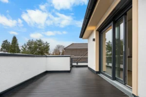 Rooftop terrace of the Pasing rental apartment with a view of a neighboring tiled roof and open terrace door