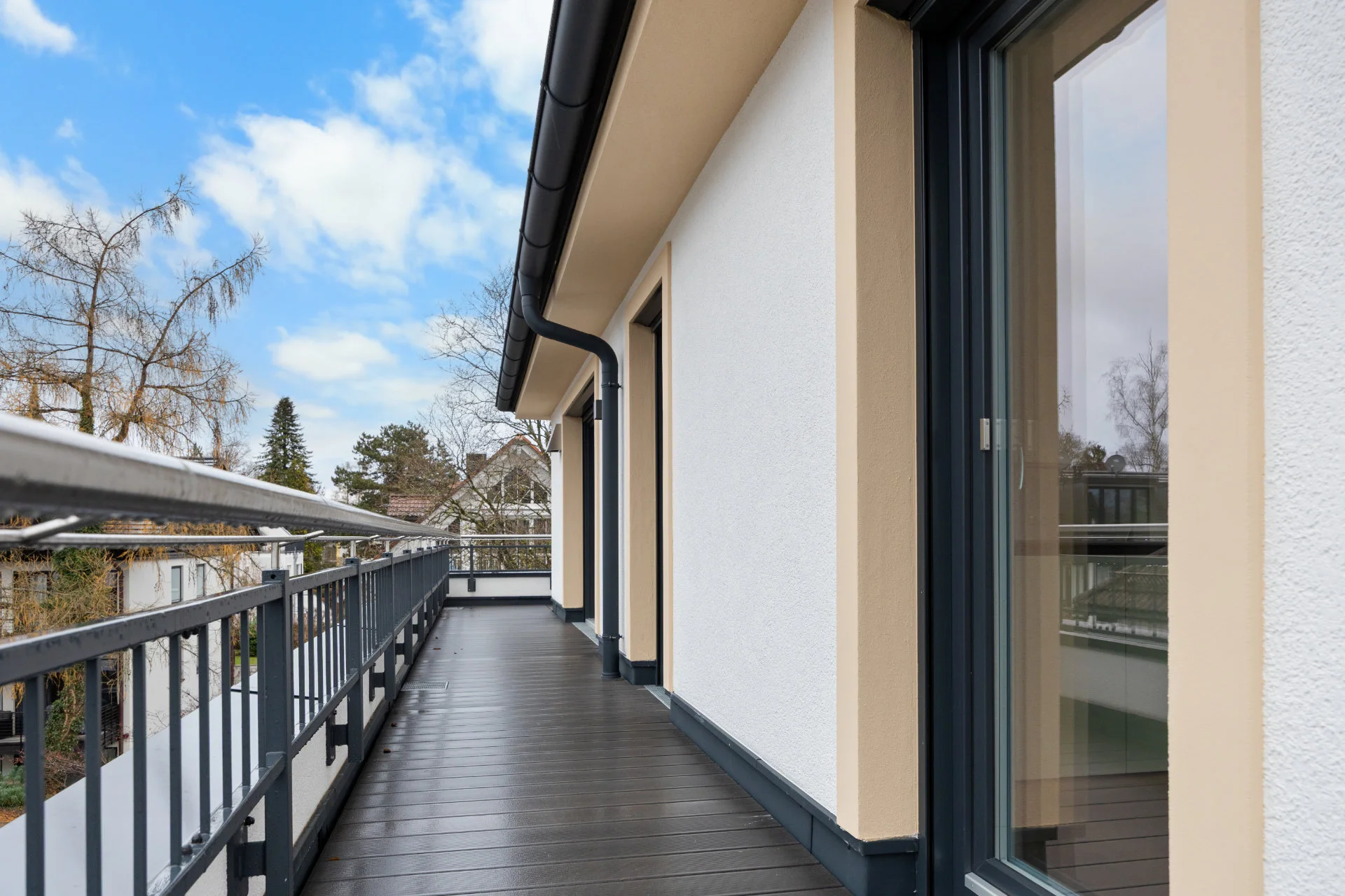 Terraced walkway of the rented apartment in Pasing along the house facade with a view of surrounding roofs