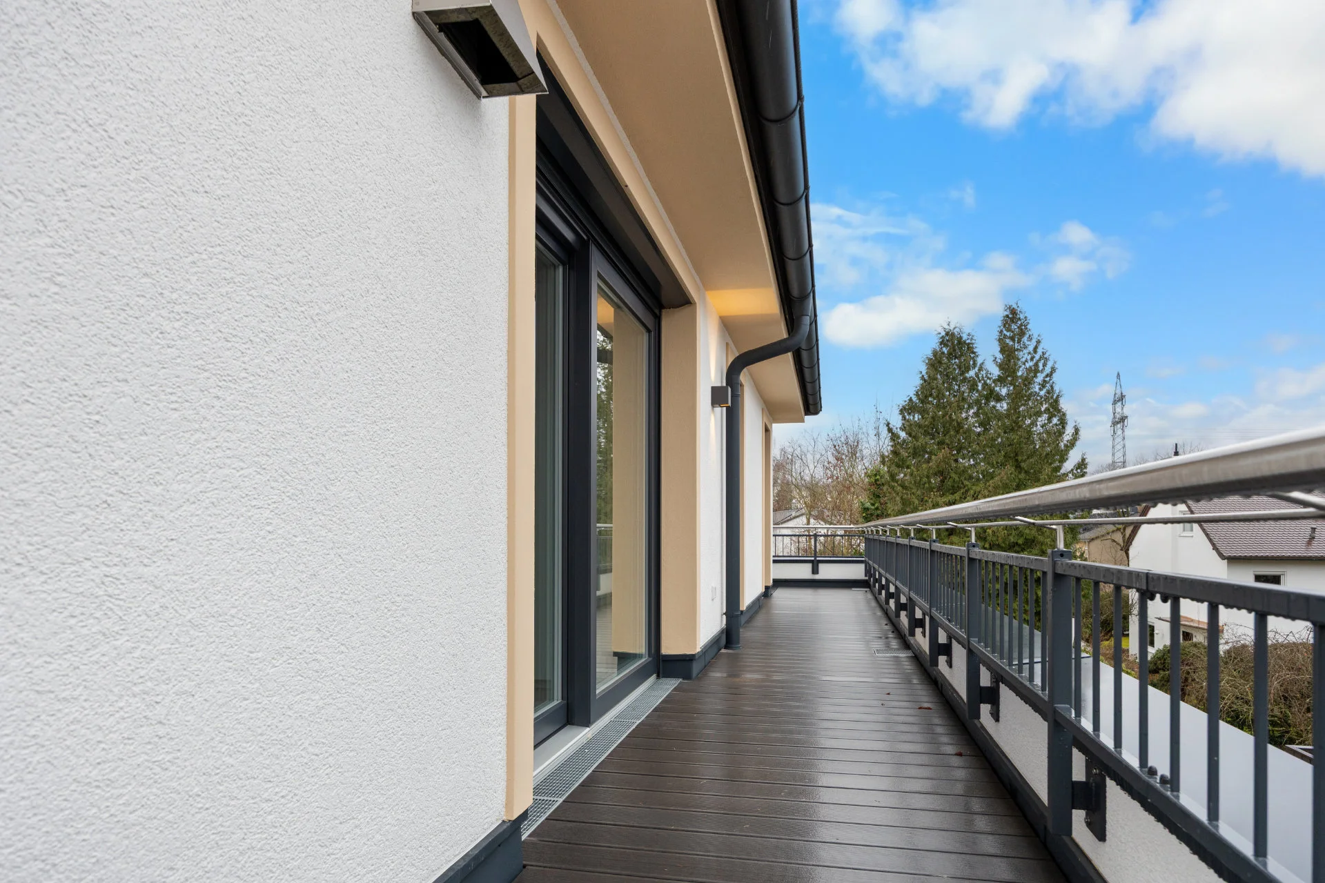 Wraparound rooftop terrace of the Pasing rental apartment with a metal railing and views over the neighborhood