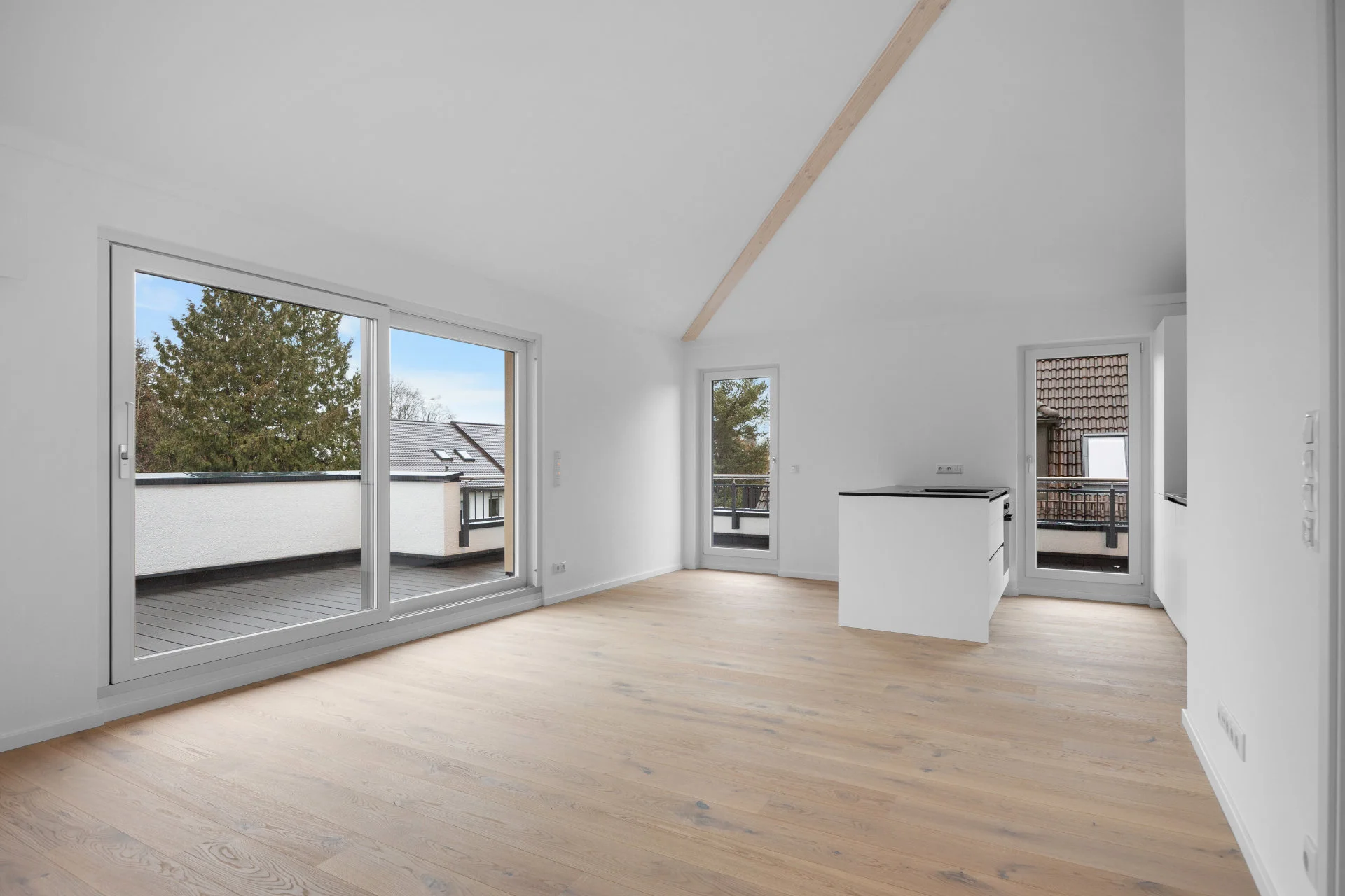 Bright living area with wooden floor, patio door and view of the open kitchen in Munich-Pasing