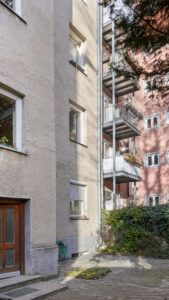 Courtyard view of the apartment building in Munich-Schwabing with balconies and entrance door