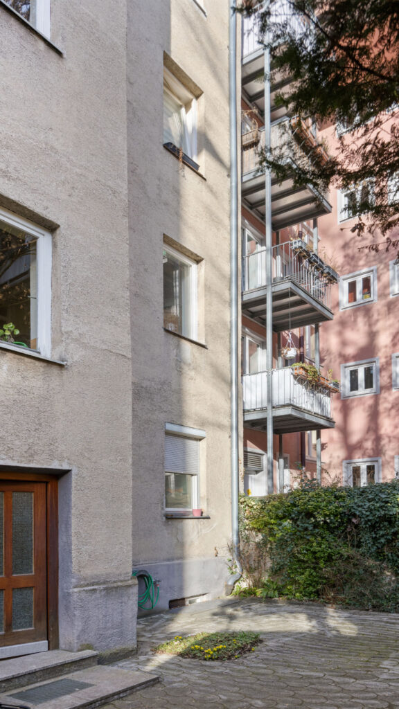 Courtyard view of the apartment building in Munich-Schwabing with balconies and entrance door